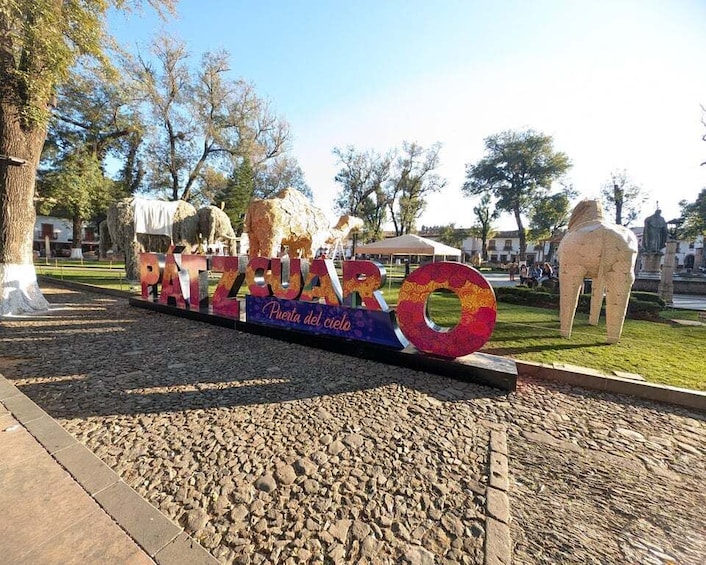A colorful sign with the name 'Punta del Cielo' and a large circular structure. 5