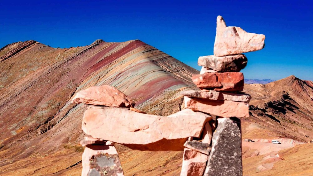 A totem pole in a mountainous landscape with layered rock formations. 2