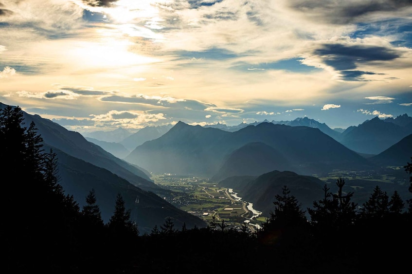 A mountainous landscape with a valley, a river, and a town. 1