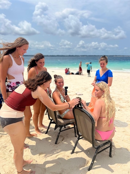 A group of people on a beach with a chair and a camera. 1