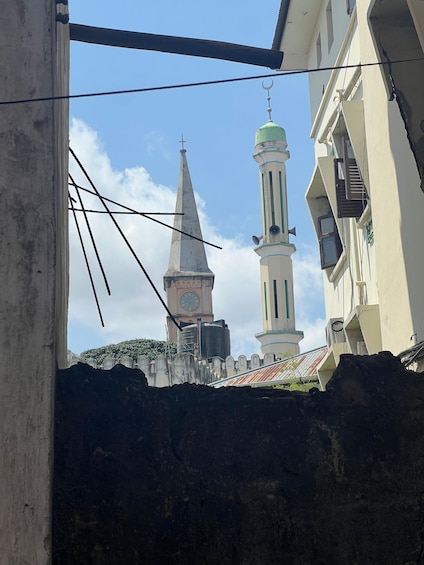A view of a mosque with a clock tower and minaret, surrounded by buildings. 5