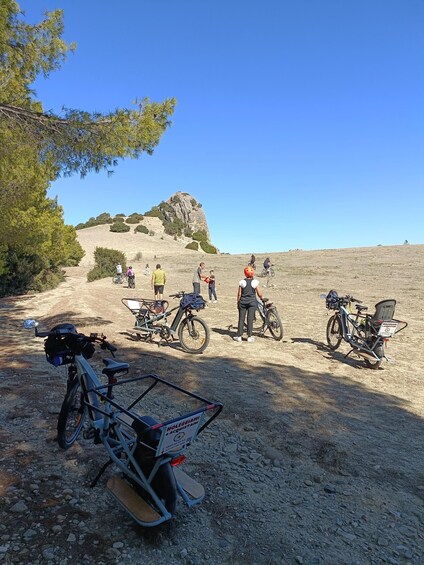 A group of people on a dirt path with bicycles and a mountain in the background. 5