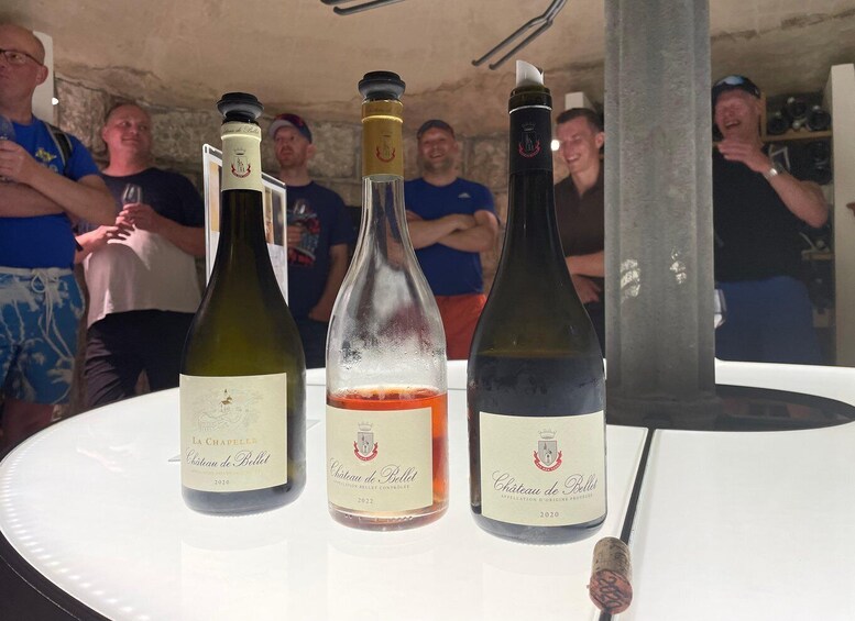 Three bottles of Chateau de Bellevue wine on a table with a corkscrew. 4