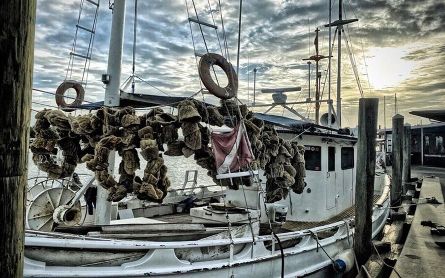 A boat docked at a pier with a cloudy sky in the background. 1