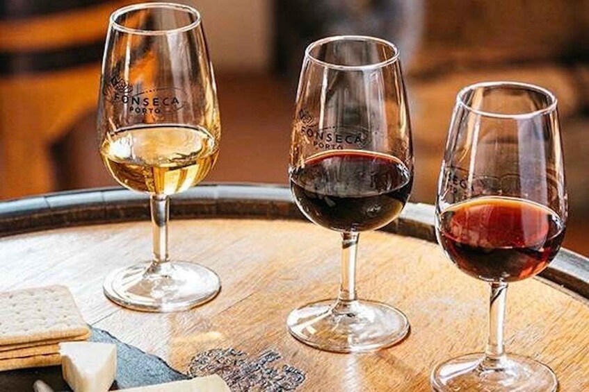 Three wine glasses on a wooden barrel. 1