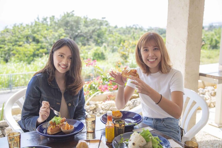 Two people dining outdoors with a table set with food and drinks. 3