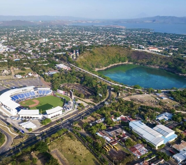 An aerial view of a stadium, a coastal road, and a large body of water. 1