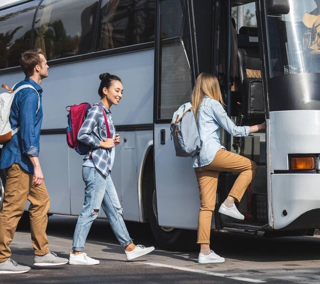 Three people boarding a bus. 5