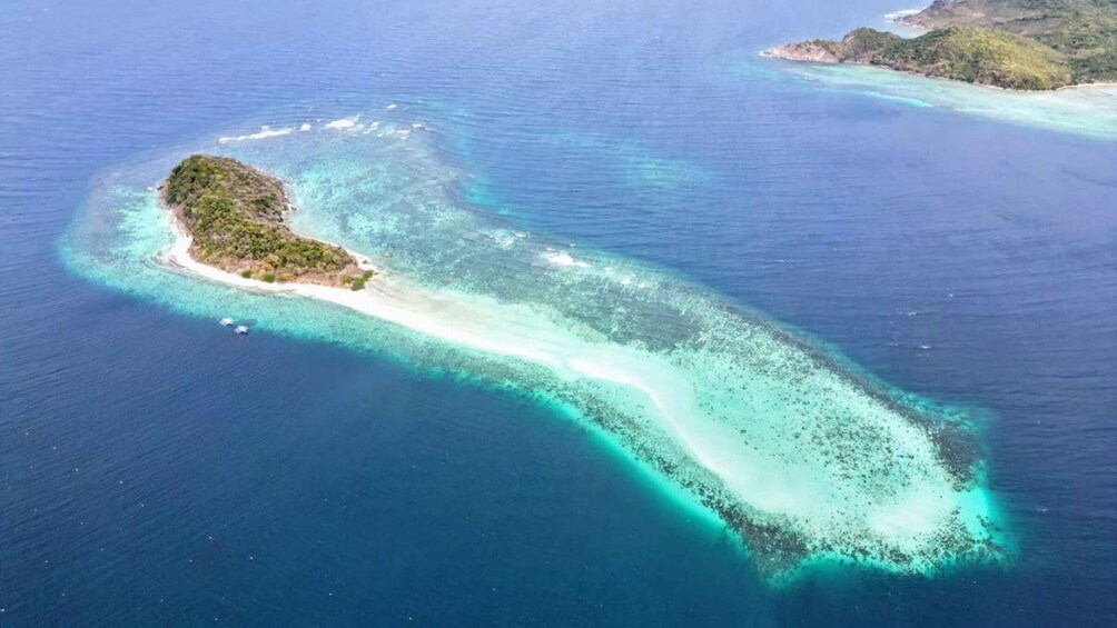 An aerial view of a narrow island with clear turquoise waters and a sandy beach. 2