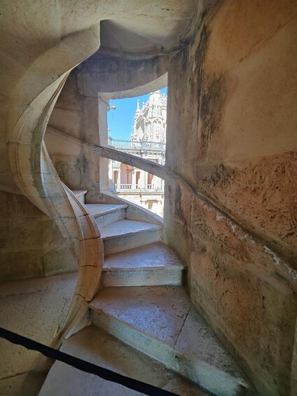 A spiral staircase with a view of a temple in the background. 2