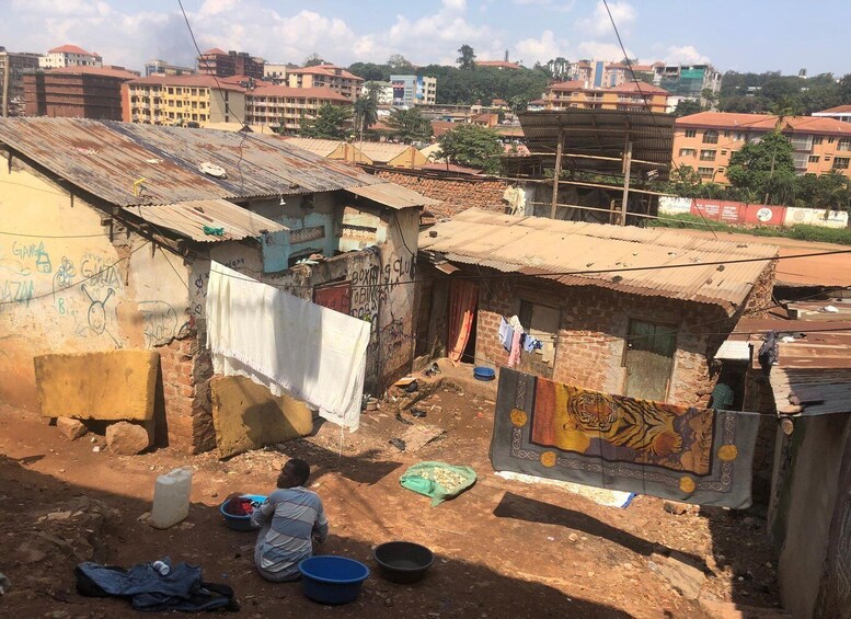 A densely populated urban area with makeshift housing and a person sitting on the ground. 1