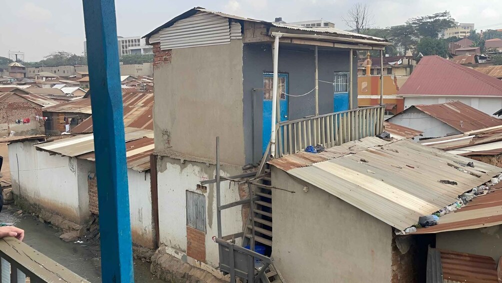 A dilapidated building with a damaged roof and a blue pole in the foreground. 3