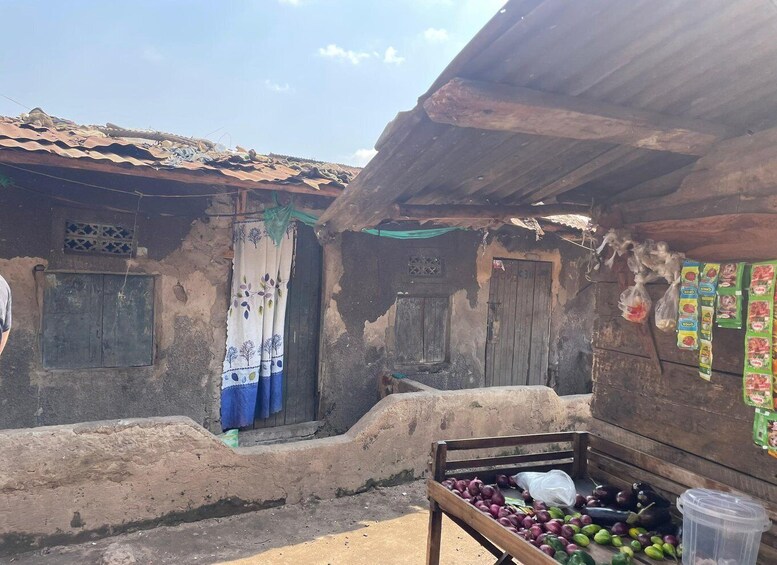 A rustic market scene with a wooden stall selling vegetables and a corrugated metal roof. 4
