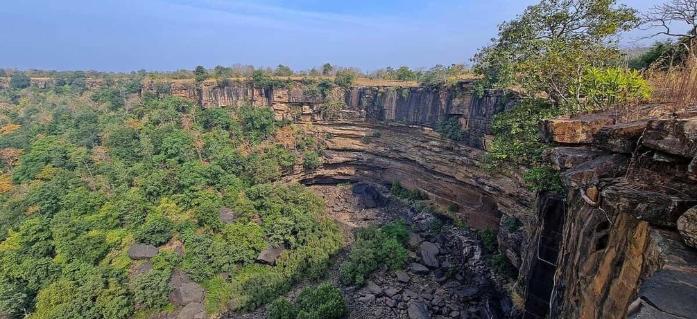 A canyon with steep cliffs and dense green vegetation. 2