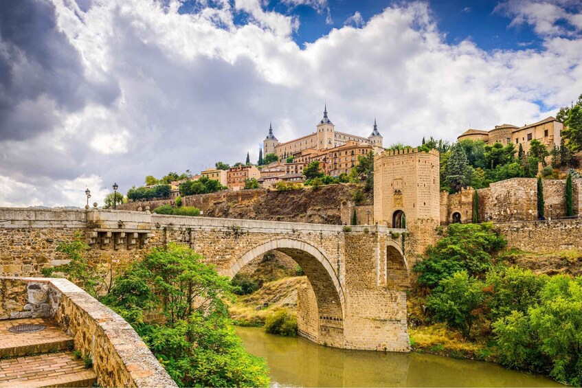 A stone bridge over a river, a castle with towers, and lush greenery. 4
