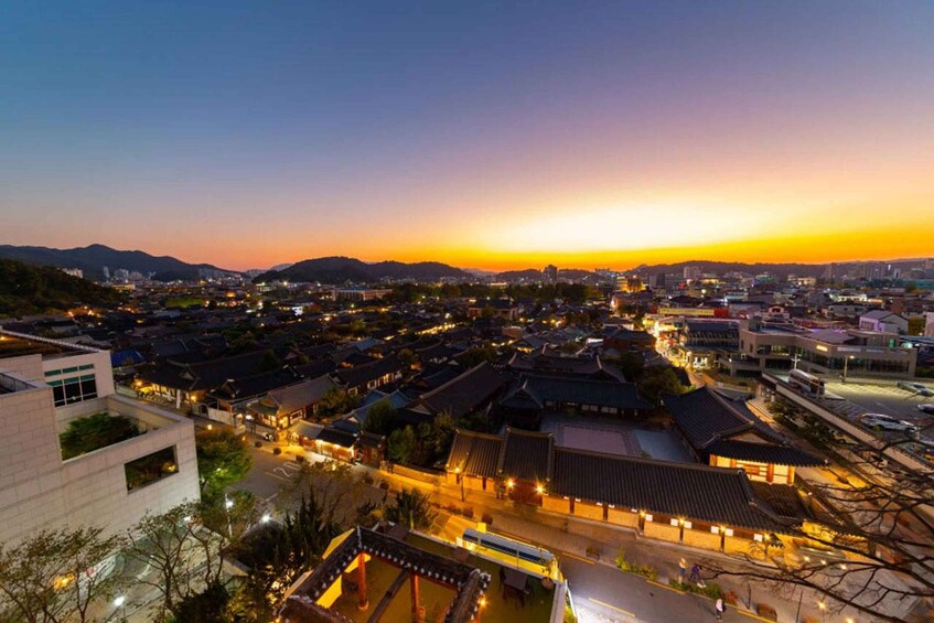 A cityscape at dusk with traditional buildings and modern structures. 1