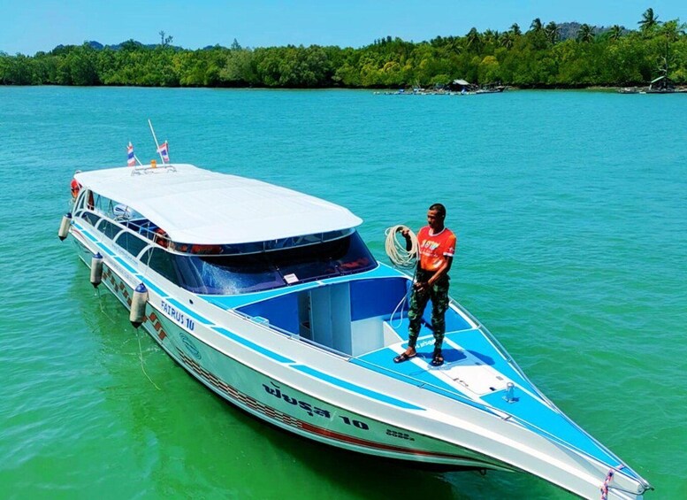 A speedboat named 'FATIS 10' on turquoise water with a person standing on the deck holding a rope. 2