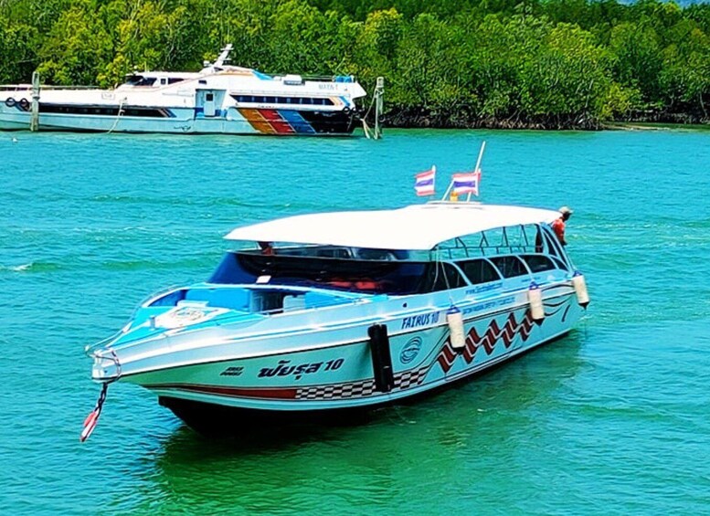 A boat named 'FAIRUS 10' on turquoise water with a forested shore in the background. 5