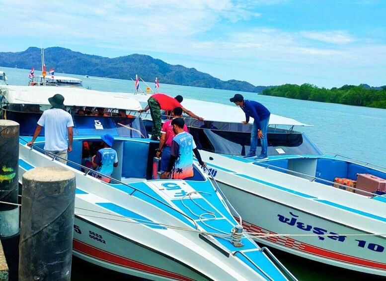 A group of boats docked at a pier with mountains in the background. 3