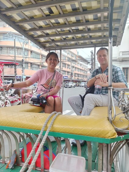 Two people on a boat with a cityscape in the background. 1