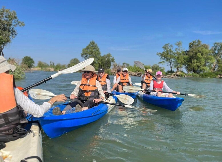 A group of people kayaking on a calm river surrounded by greenery. 4