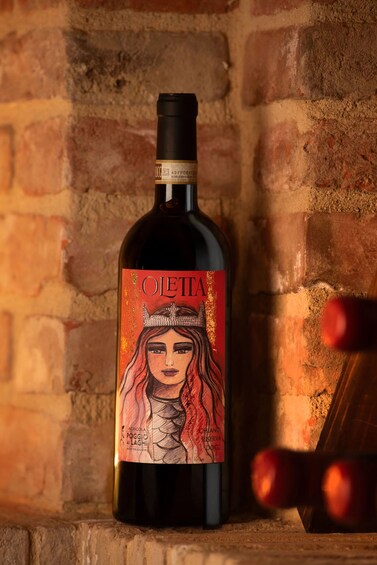 A bottle of wine with a detailed label, placed against a brick wall background. 4