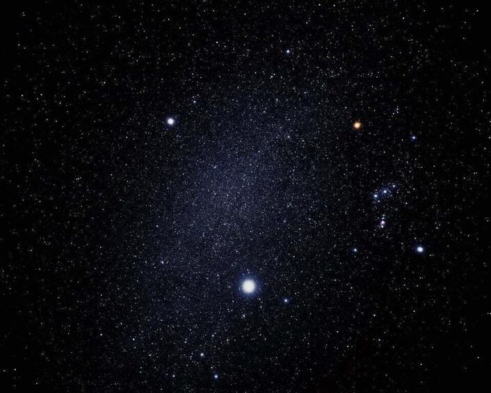 A starry night sky with a dense cluster of stars and a few bright celestial objects. 5