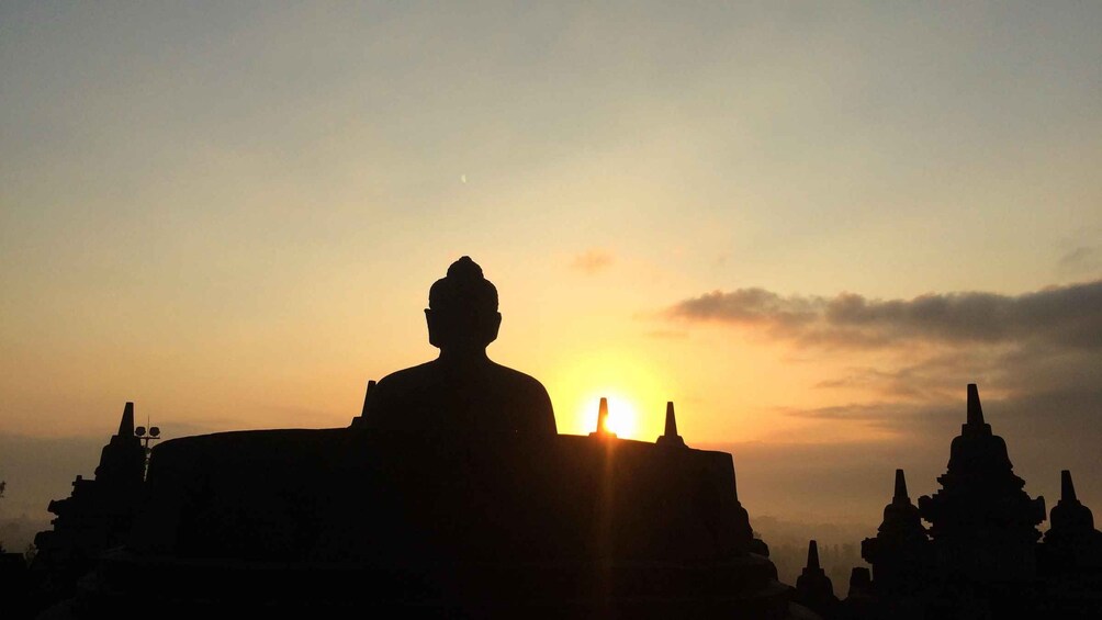 A silhouette of a large temple against a sunset sky. 1