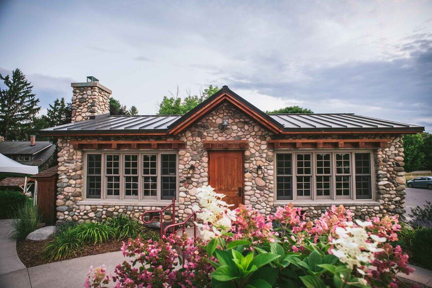 A stone house with a metal roof, wooden door, and windows. 4