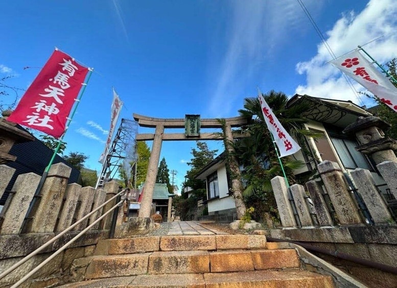 A traditional Japanese torii gate at the entrance of a shrine, with stone steps leading up to it. 4