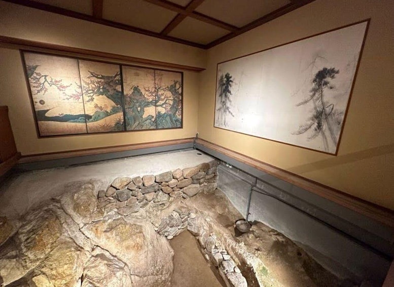 A room with traditional Japanese artwork and a stone floor. 3