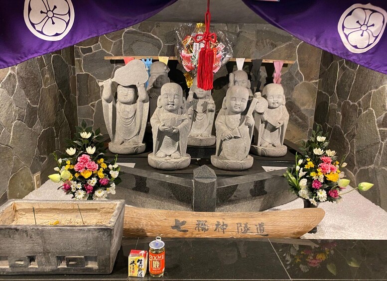 A stone altar with statues, flowers, and offerings. 1
