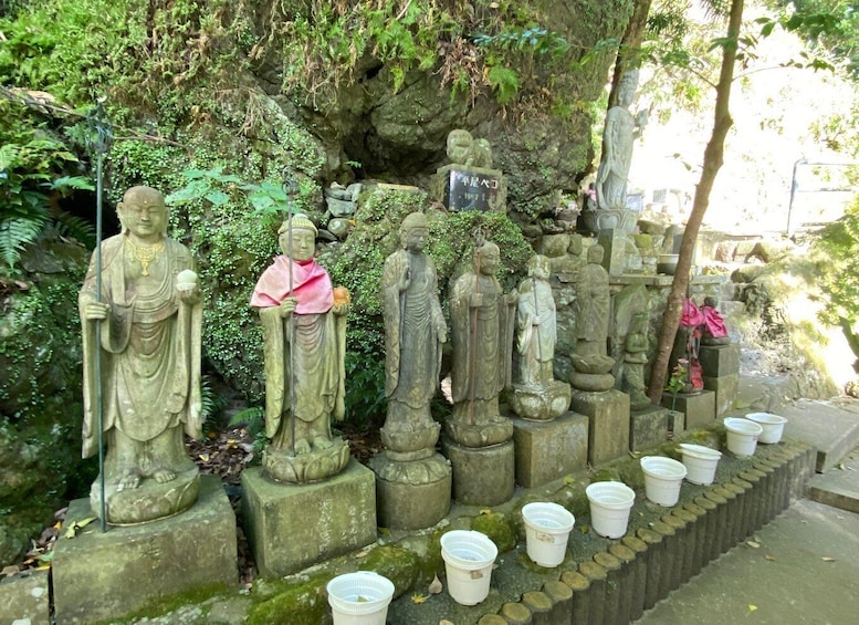 A collection of stone statues in a garden setting. 3