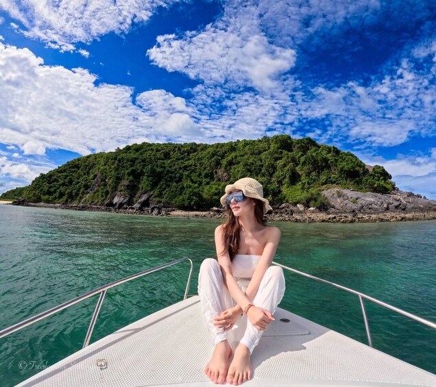 A person sitting on a boat with a mountainous landscape in the background. 5