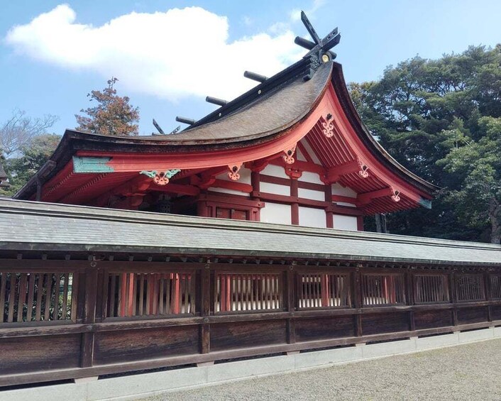 A traditional Japanese building with a curved roof and red accents. 1