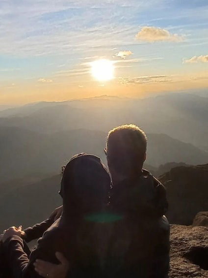Two people taking a selfie with the sun setting in the background. 2