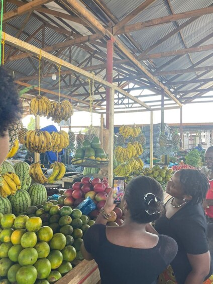 A market with various fruits like bananas, watermelons, and apples. 2