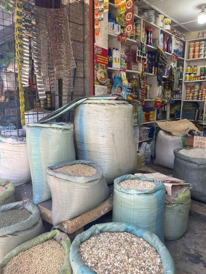 A store with large sacks of grains and various packaged goods on shelves. 3