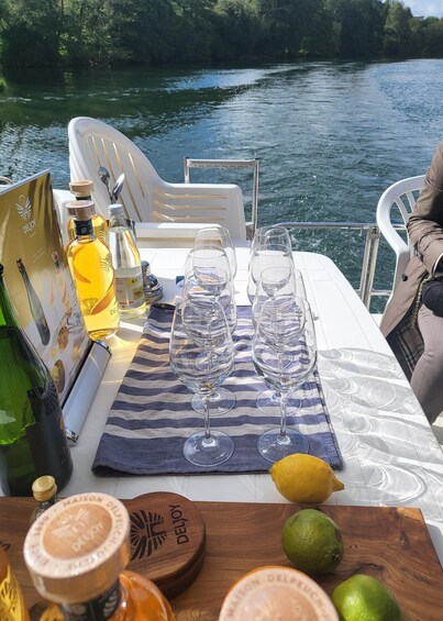A boat table set with wine glasses, bottles, and a lemon. 1