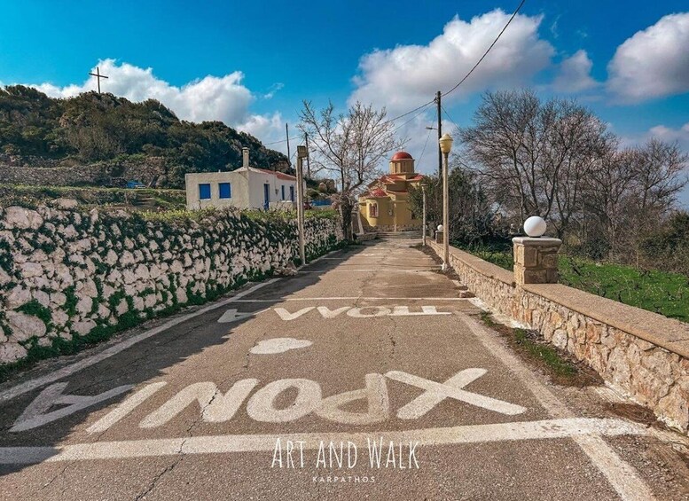 A paved road with 'ART AND WALK' painted on it, leading to a building with a red dome. 2
