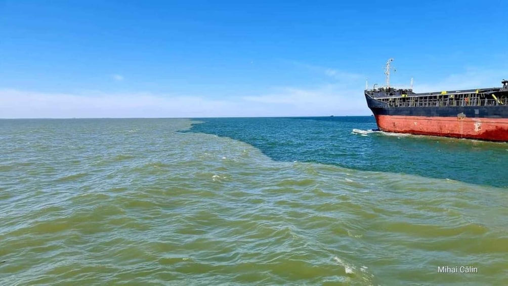 A large cargo ship on the ocean with clear skies. 1