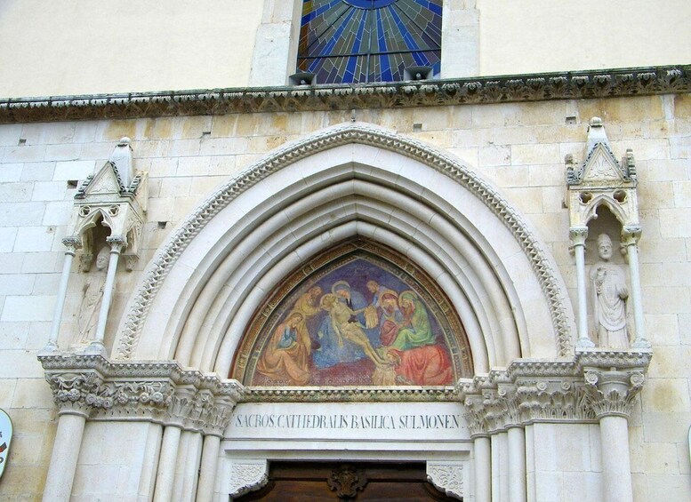 A Gothic arch with a religious mural and inscriptions. 4