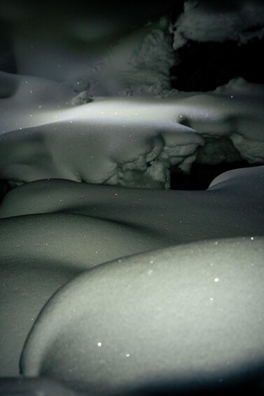 A snowy landscape with undulating terrain and distant snow-covered hills. 4