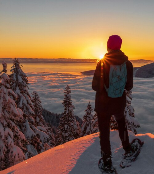 A person snowboarding on a snowy mountain slope during sunset. 5