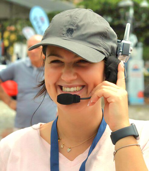 A person wearing a cap and a microphone headset, holding a device. 5