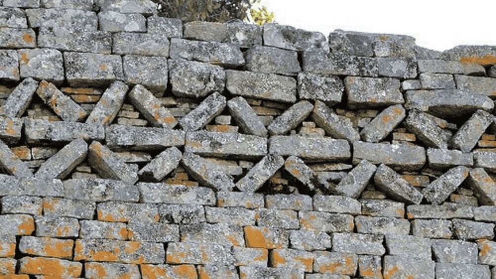 A stone wall with a geometric pattern of interlocking stones. 4