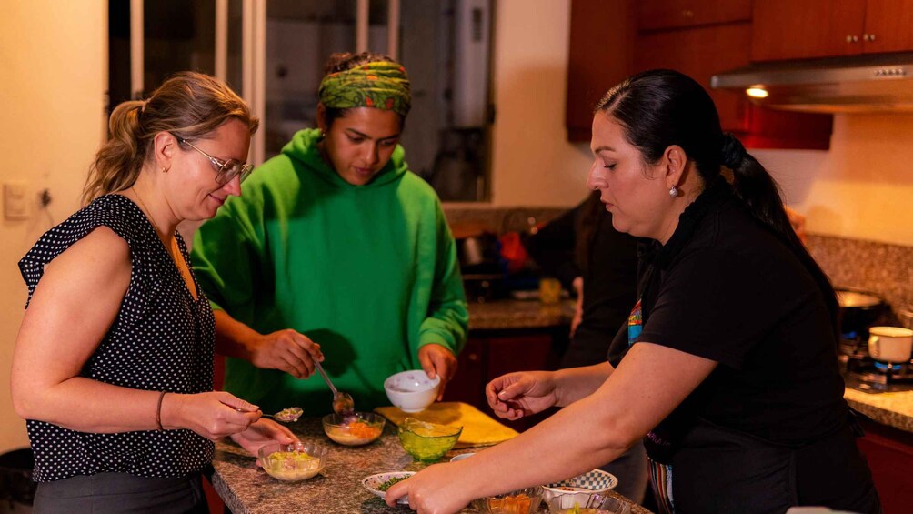 Three people cooking together in a kitchen. 2