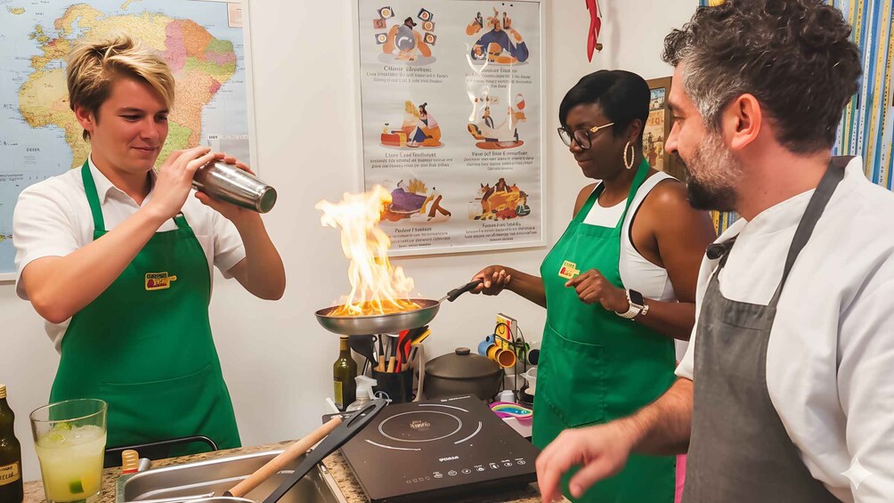Chefs preparing food with a wok on a portable stove. 1