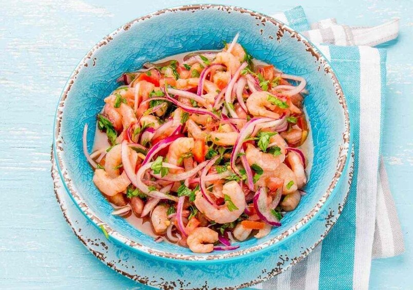 A bowl of shrimp salad with red onions and herbs. 3