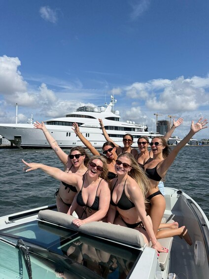 A group of people on a boat with a large yacht in the background. 5
